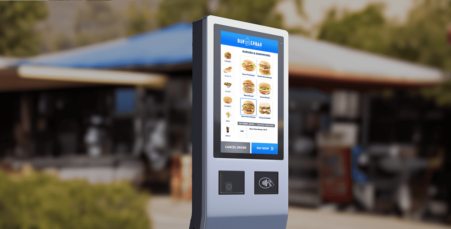 Outdoor-Touchscreen-Kiosk mit digitaler Speisekarte eines Burger-Restaurants, der KI-gestützte Drive-Through-Bestelltechnologie in einem QSR-Umfeld zeigt.